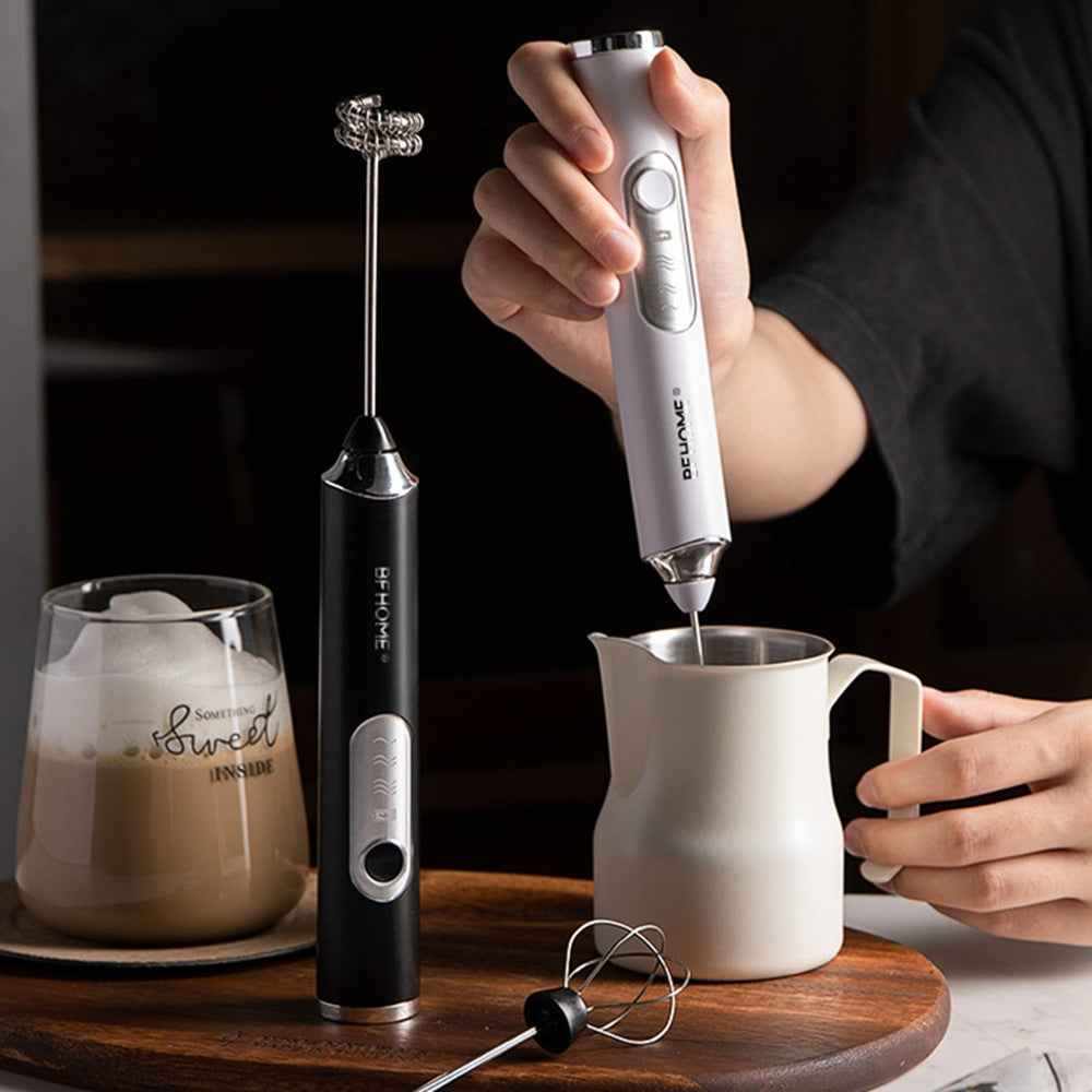 Compact USB rechargeable milk frother with stainless steel whisk and replaceable brush heads in black and white